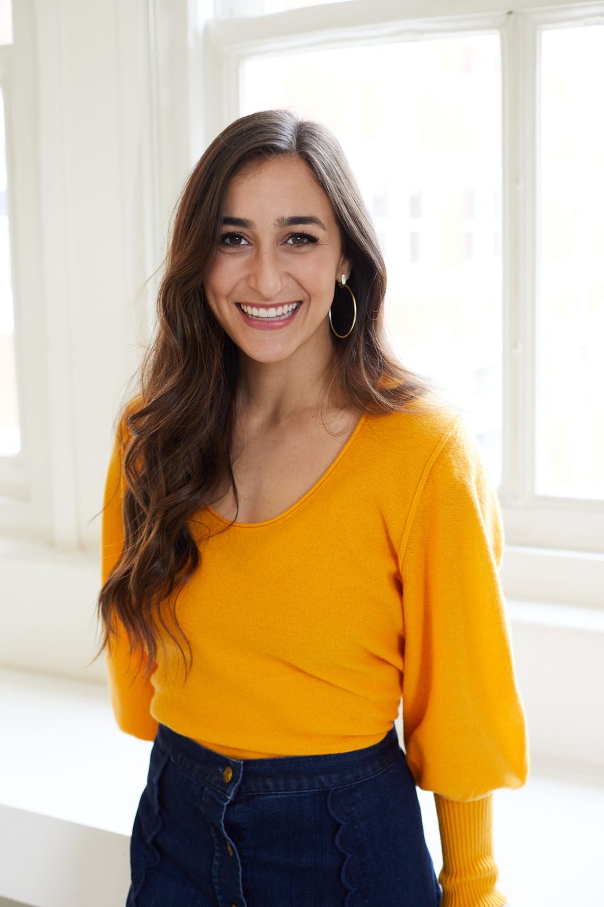 Desirae Terry, LCSW, standing by a window in a mustard sweater